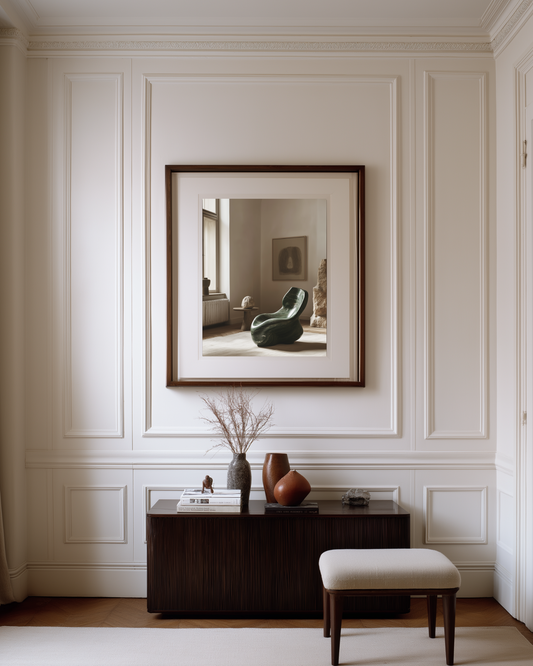 Framed artwork on a wall with decorative vases and a stool below
