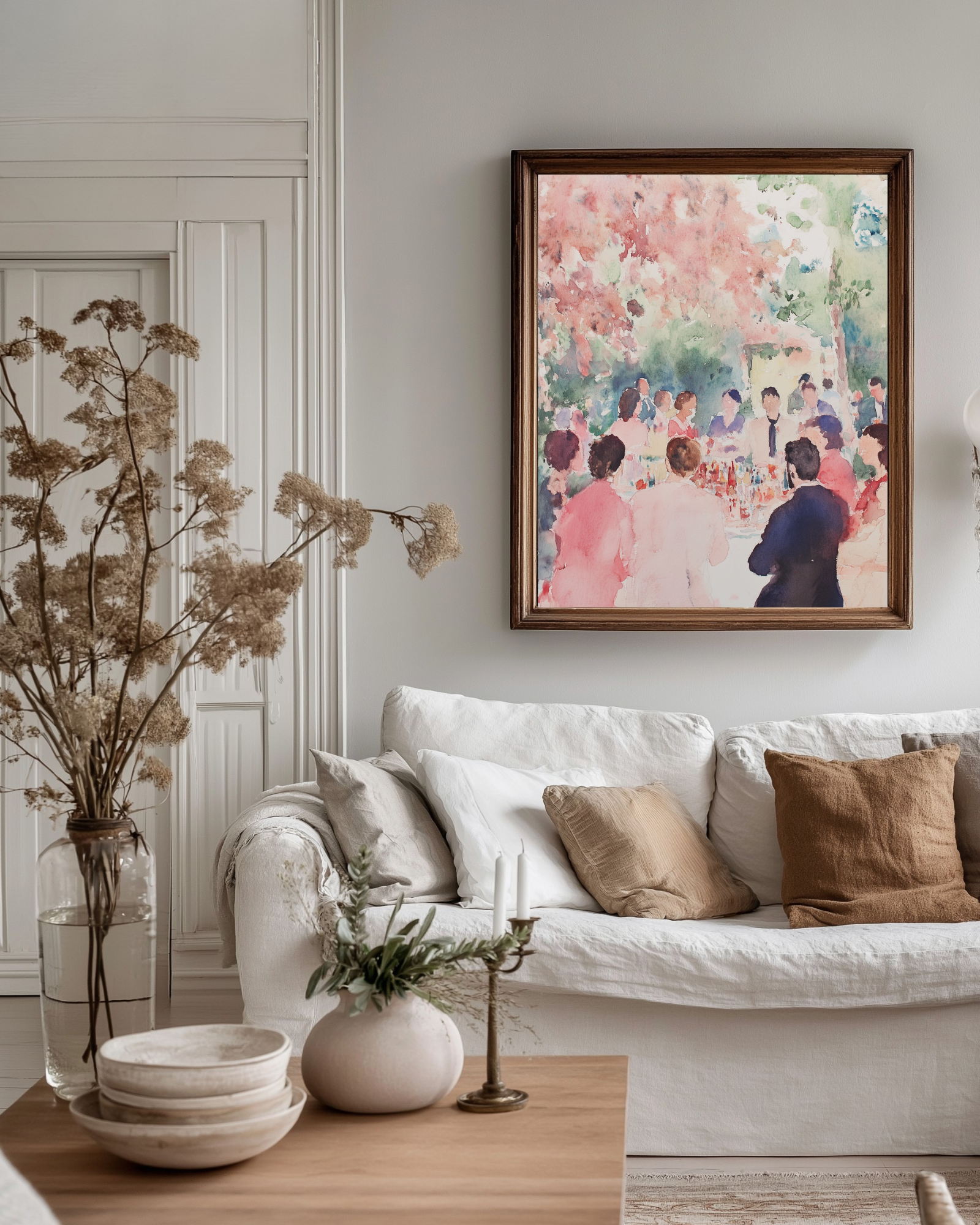 Country style living room with a white sofa, decorative linen pillows, and a colorful pink watercolor painting on the wall.