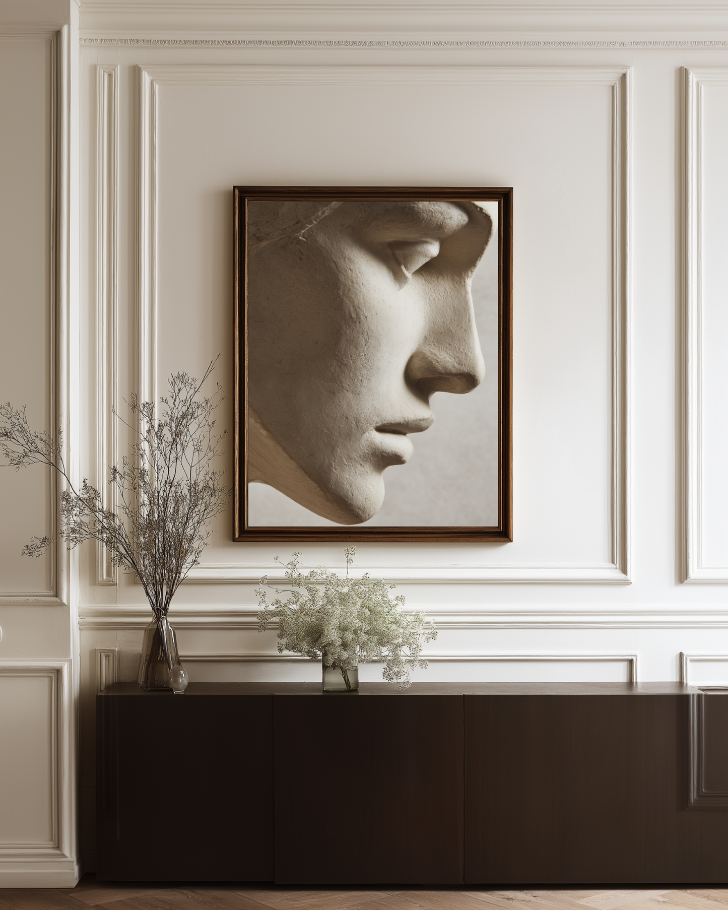 Framed artwork of a classical sculpture on a wall with decorative elements.