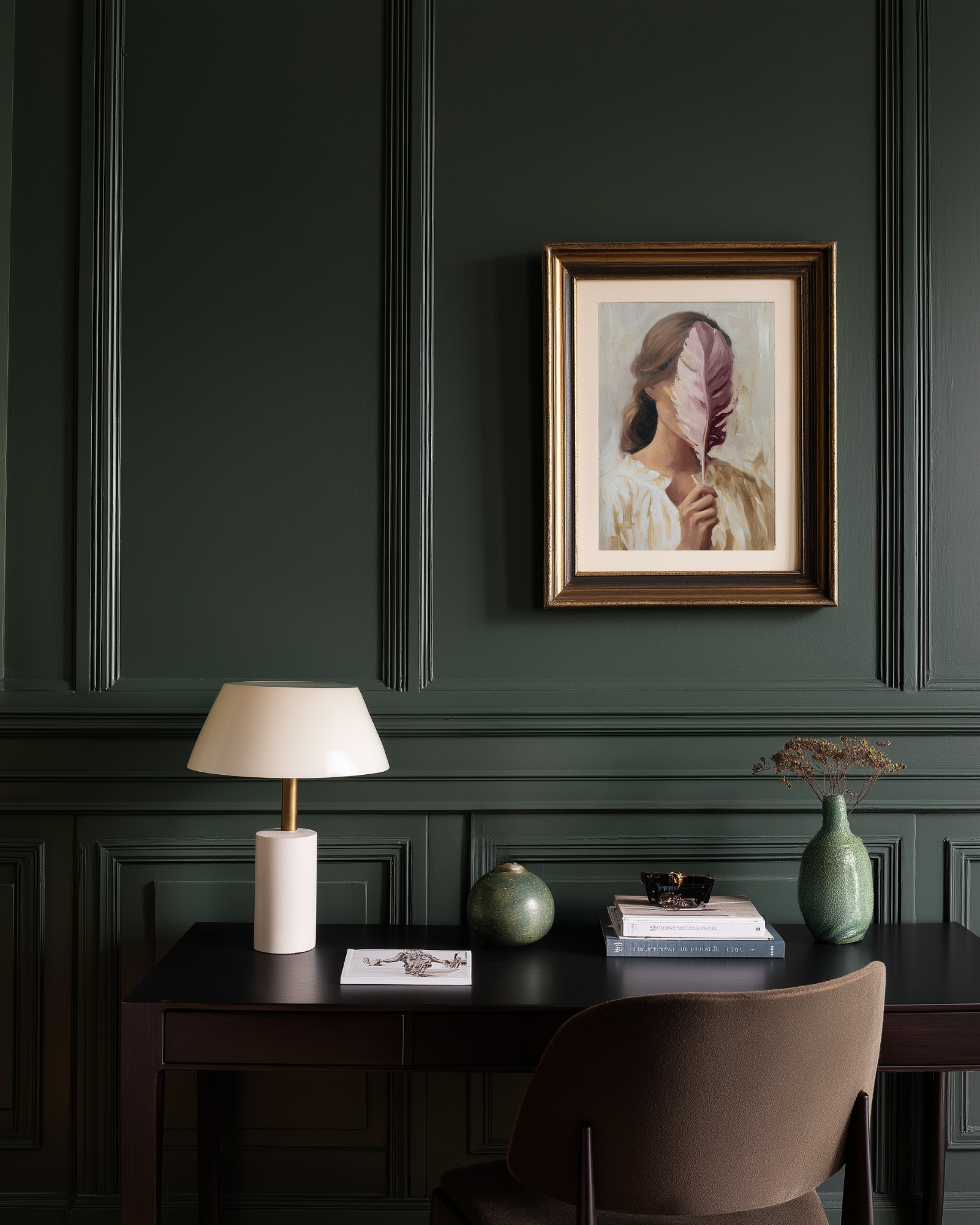 Green home office with a poster of a woman covering her face with a feather