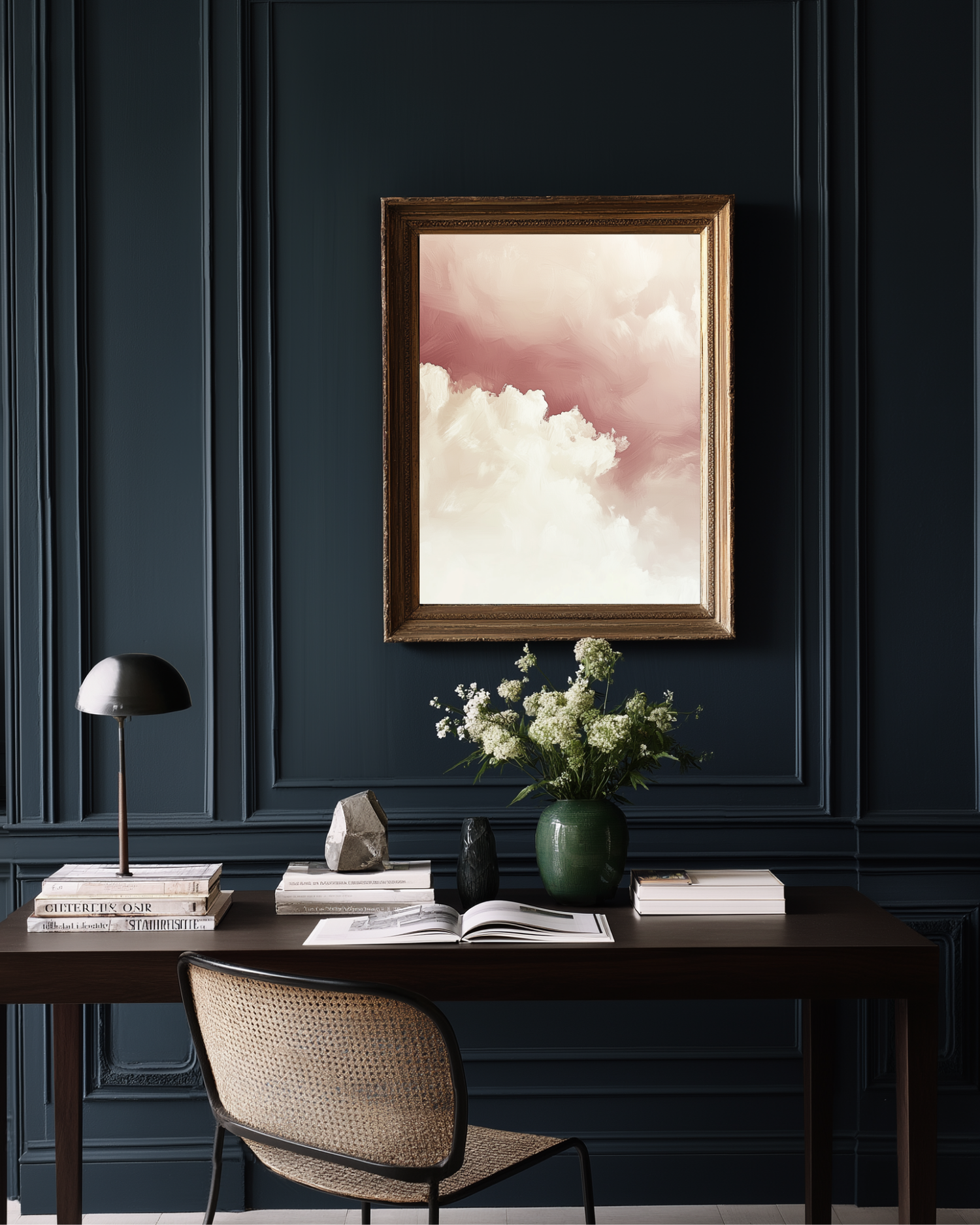 Home office with a dark blue paneled wall and pink skies abstract wall art.