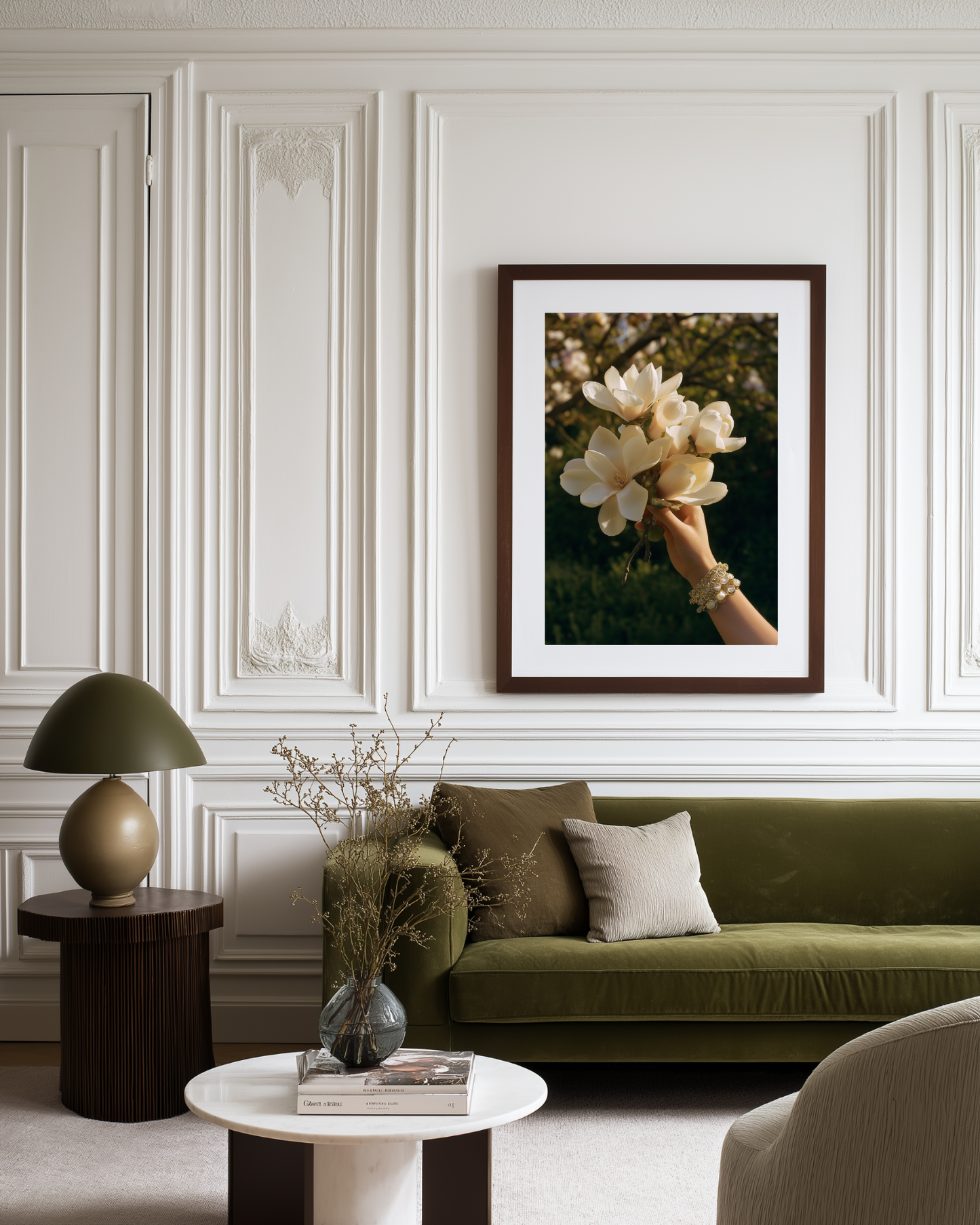 Living room with a green sofa, decorative lamp, and framed poster with flowers on the wall.