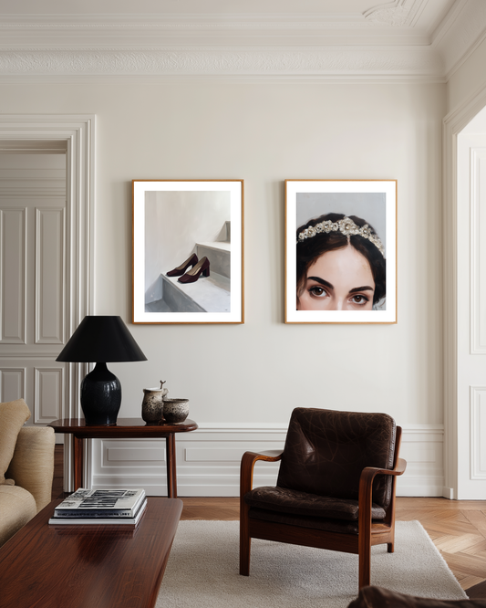 Living room with two framed fashion pictures on the wall, a brown armchair, and a coffee table.