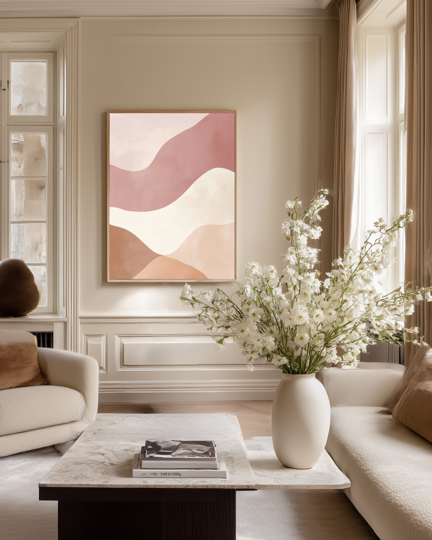 Luxury living room with abstract pink and white soft colored wall art, a white vase with flowers, and books on a coffee table.