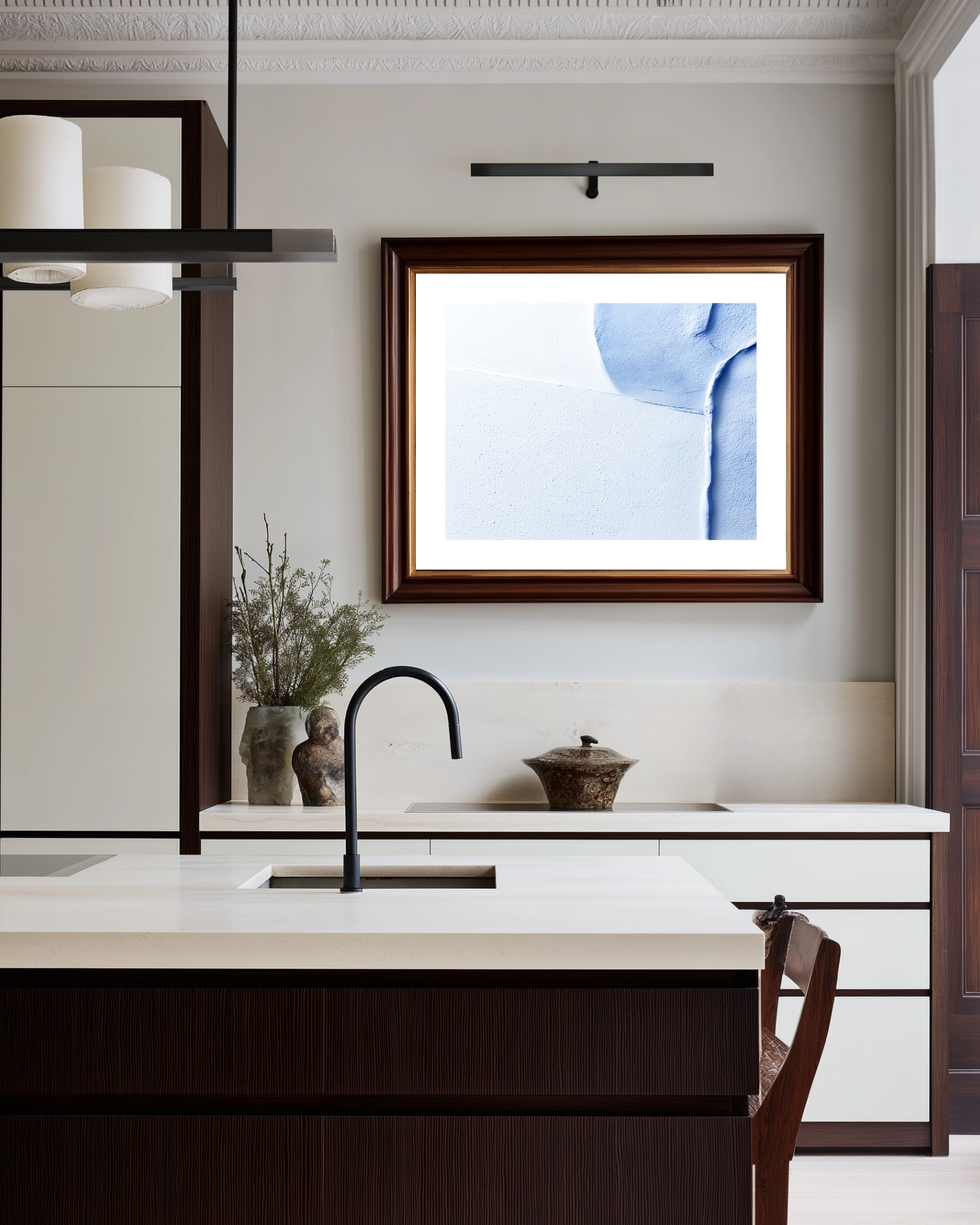 Modern kitchen with white island, black faucet, and abstract light blue art on the wall.