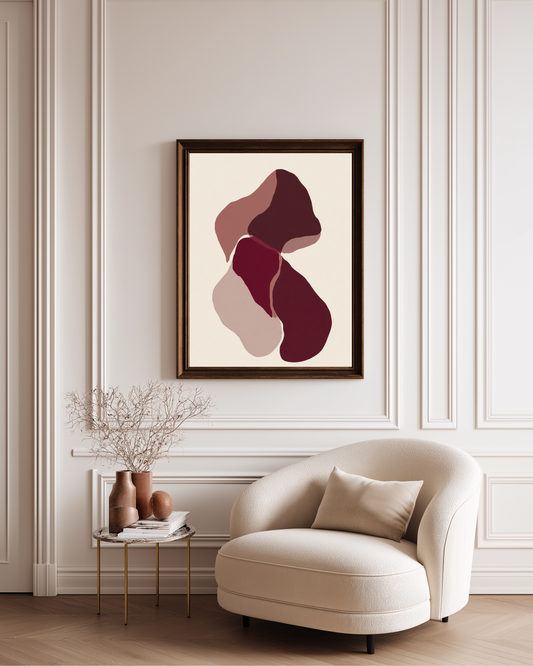 Modern living room with a beige armchair, abstract burgundy and bordeaux modern art on the wall, and a small table with decorative items.