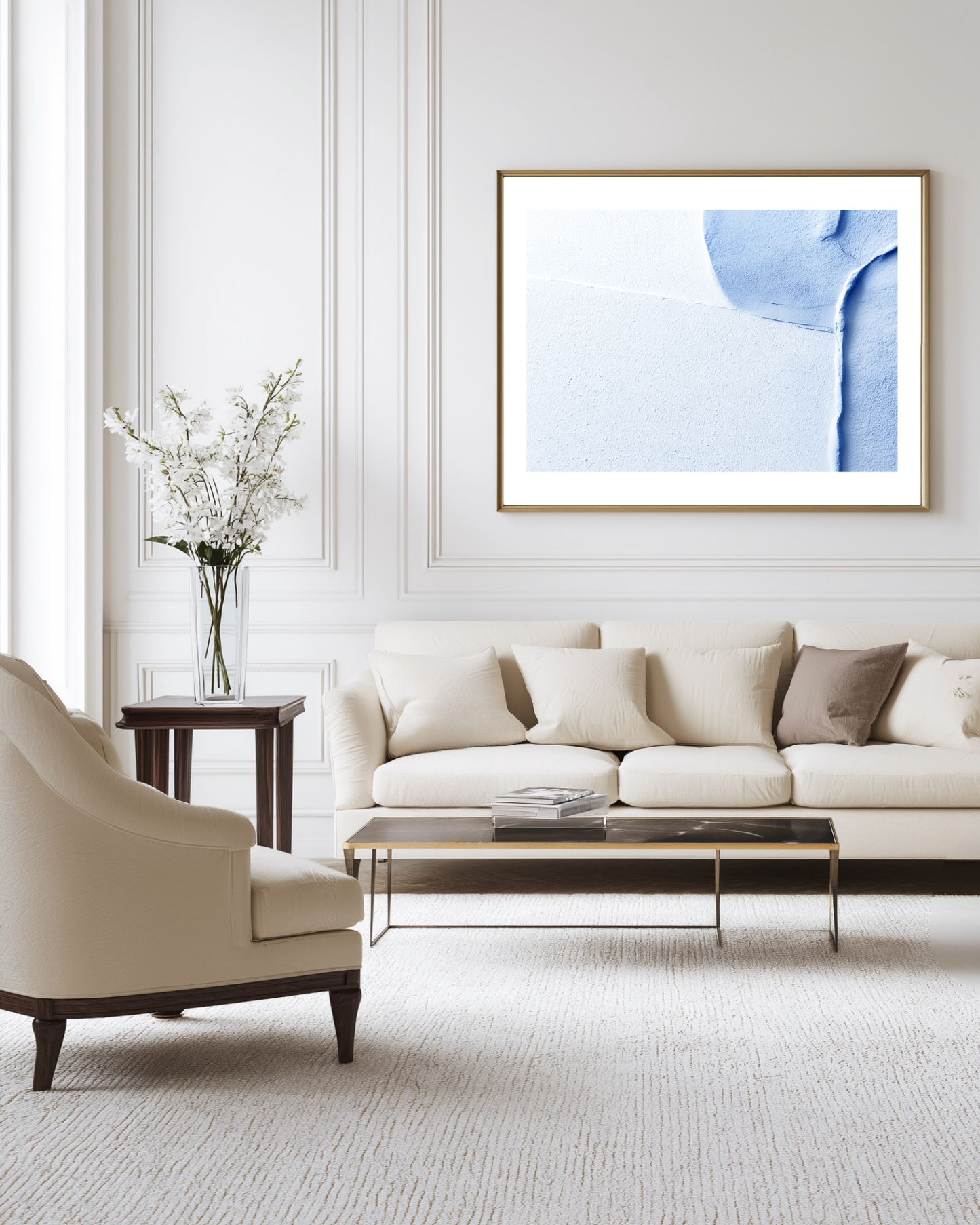 Modern living room with a beige sofa, armchair, and abstract artwork on the wall.