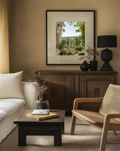 Living room with a sofa, armchair, coffee table and framed italian photography wall art on the wall.