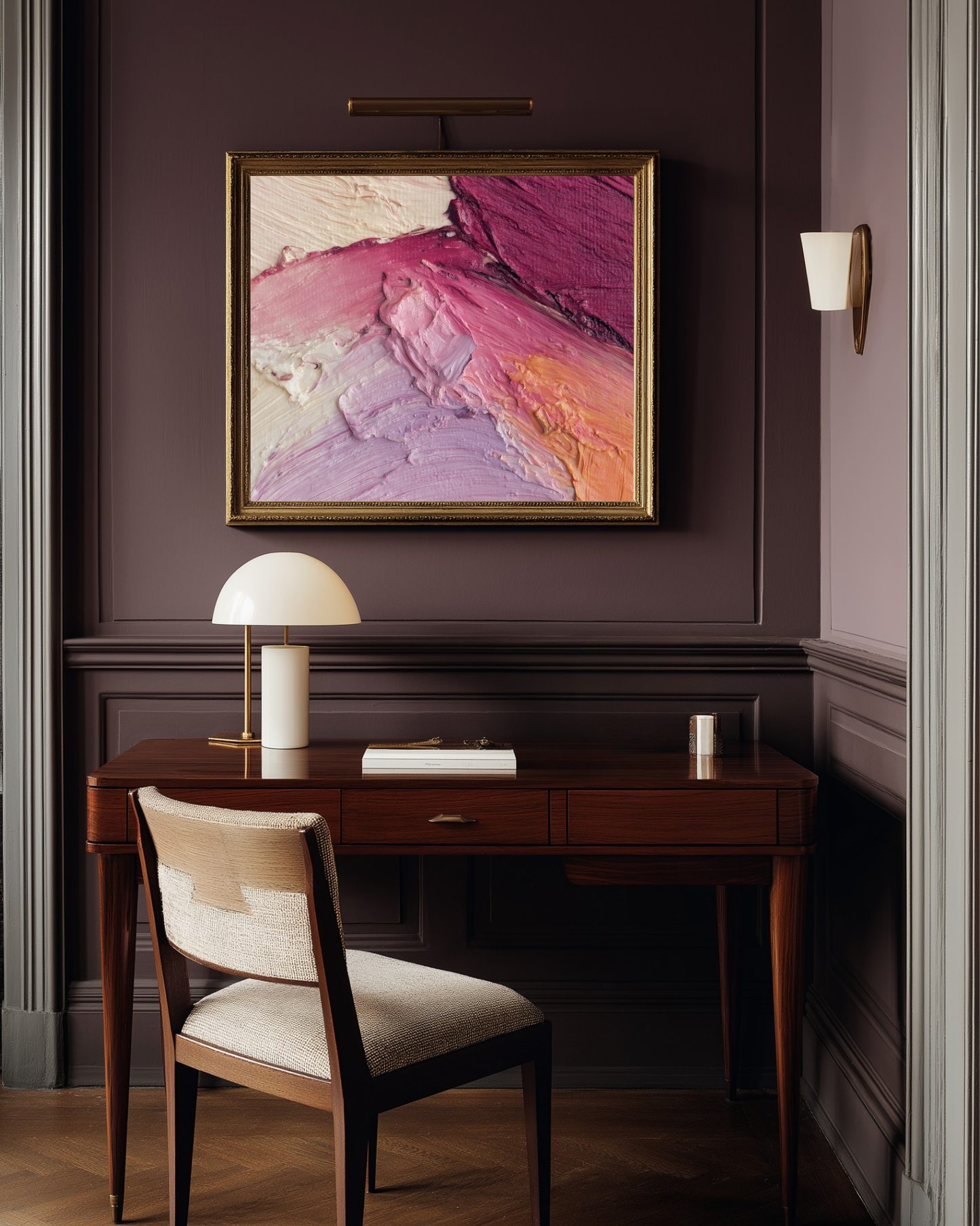 Stylish home office with a wooden desk, chair, and abstract pink and purple makeup art on a purple wall.