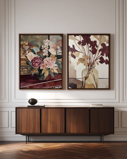 Two framed floral luxury art prints on a wall above a wooden cabinet.