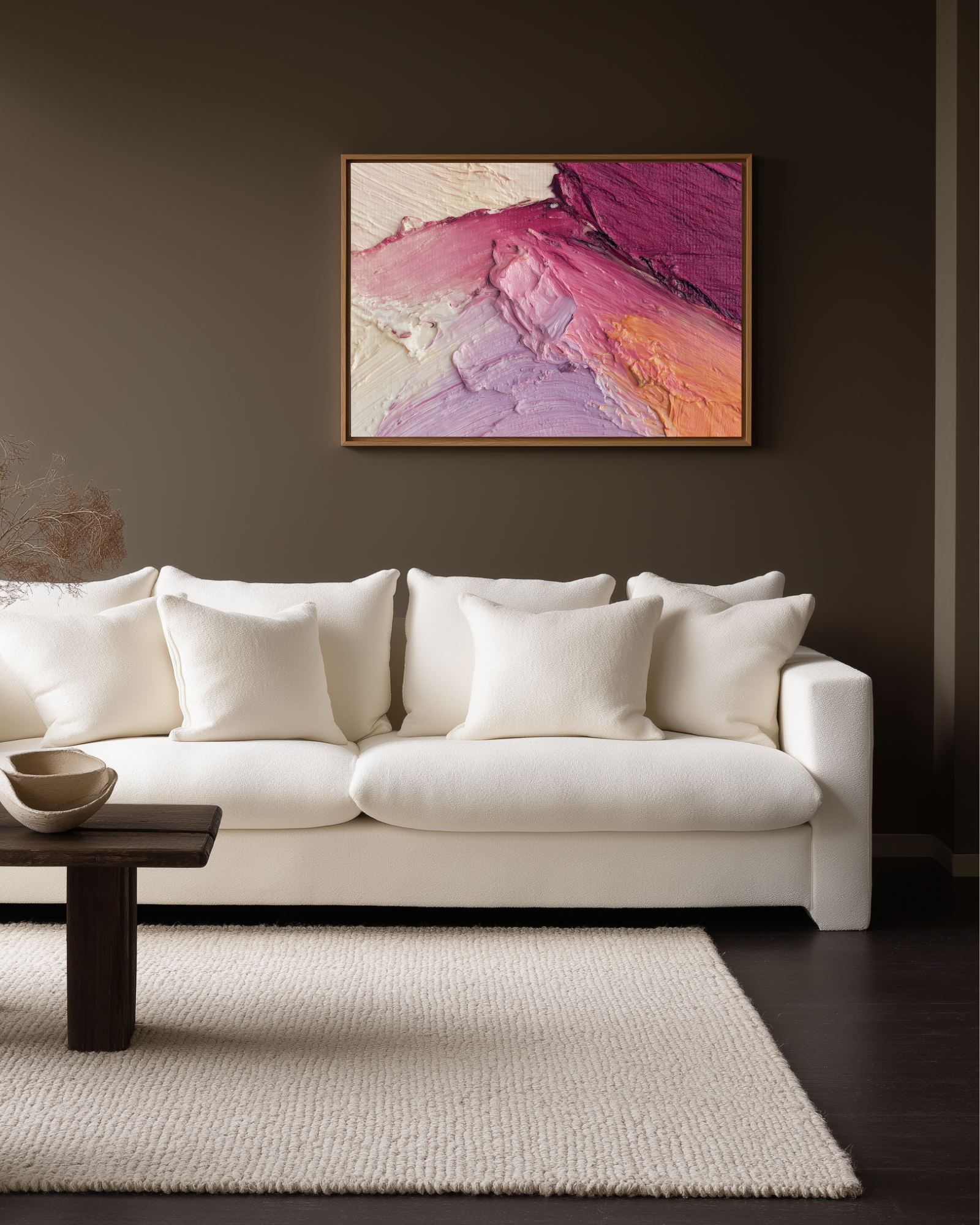 White sofa in a living room with a colorful abstract pink and purple makeup painting on the wall.
