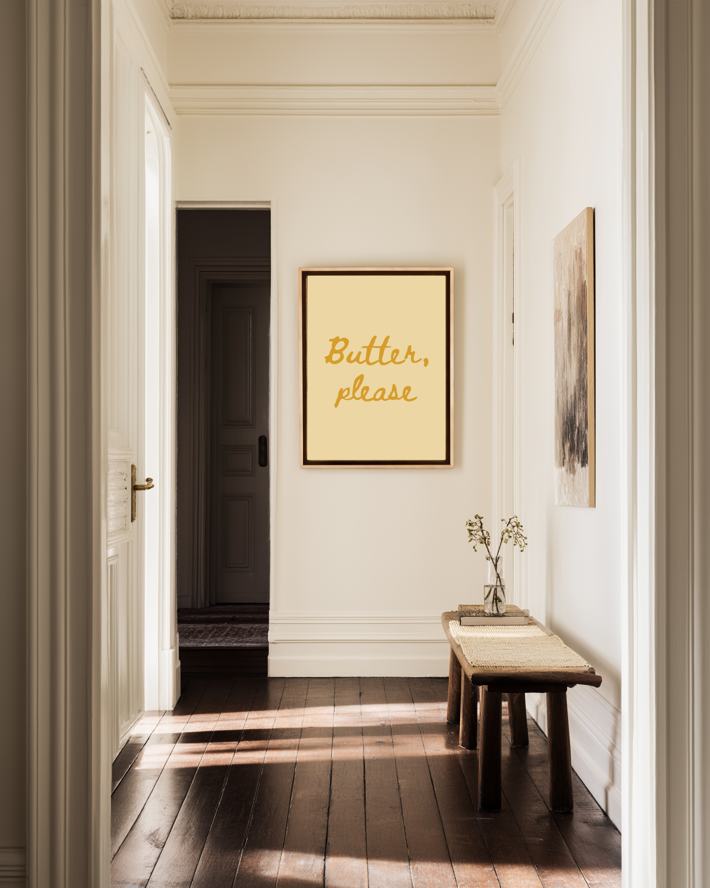 a hallway with wall art, a butter yellow poster with text "butter, please".