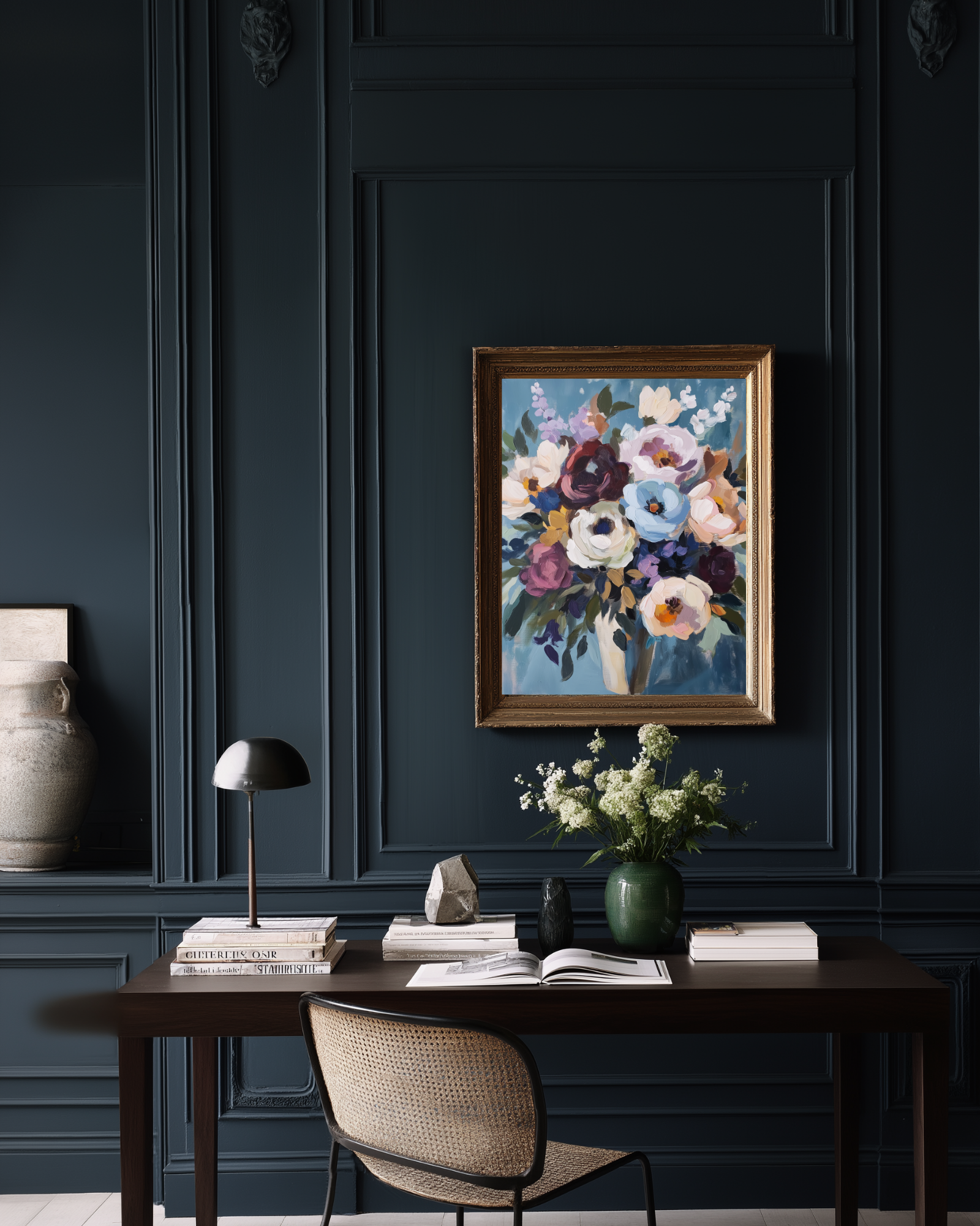 Decorative floral painting on a dark wall above a desk with books and a lamp.
