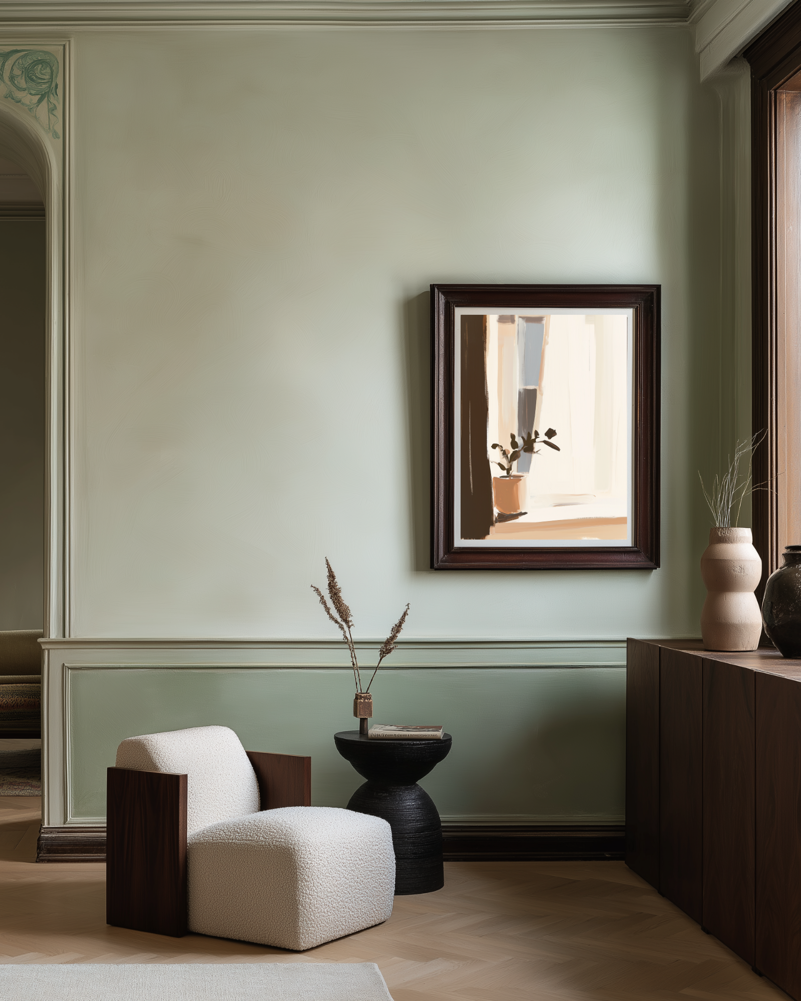 Modern interior with a white armchair, black side table, and framed mirror on a light green wall.