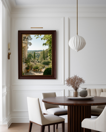 Dining room with a framed landscape painting on the wall, wooden table, and white chairs.