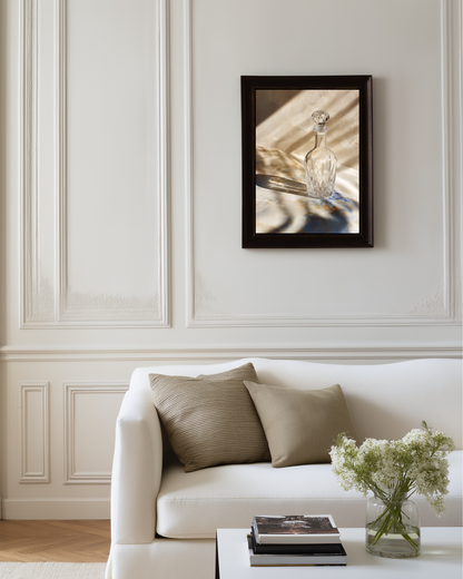 minimalist photography poster of a glass carafe above a white sofa in a living room with neutral decor.