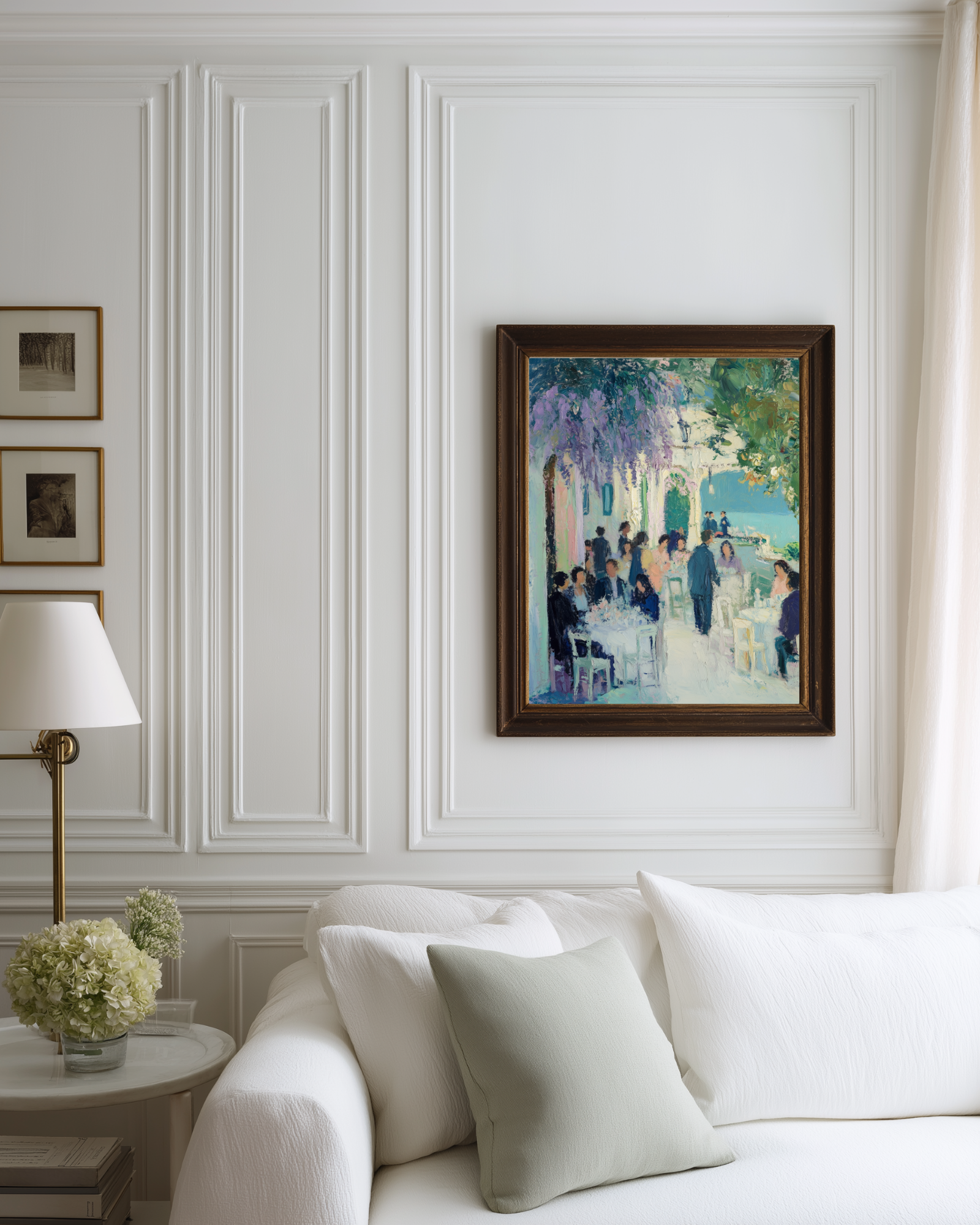 Framed blue mediterranean art on a white wall above a white sofa in a stylish Hamptons style room.